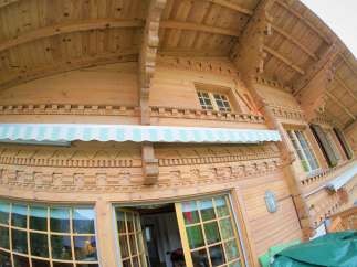 Discover the charm of this stunning wooden chalet, showcasing intricate carvings and a warm, inviting ambiance.
