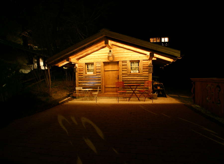 Cozy cabin at night with warm lighting.