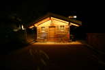 Cozy cabin at night with warm lighting.