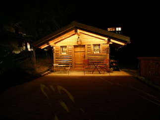 Cozy cabin at night with warm lighting.