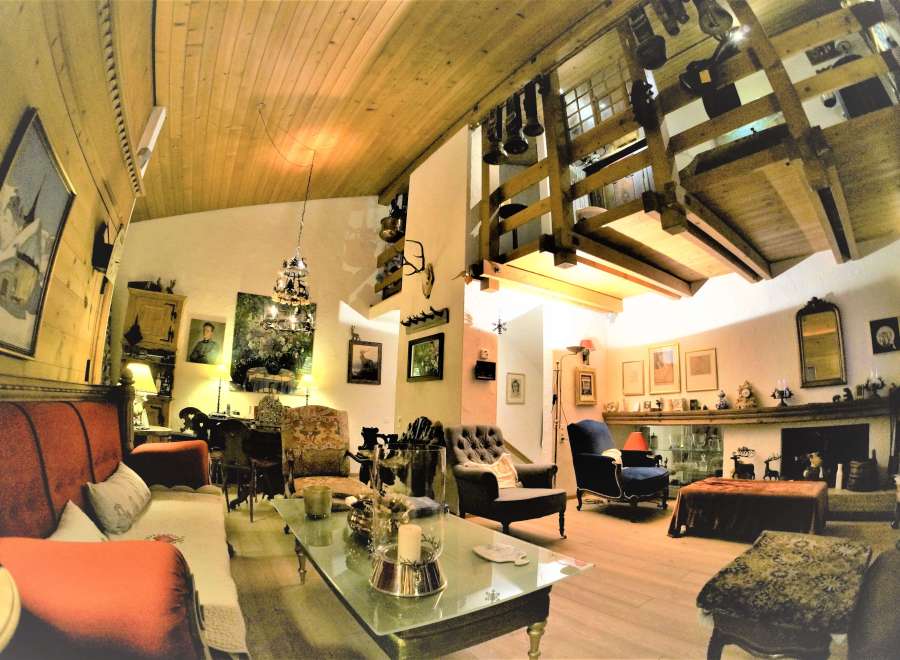 Step into a cozy living space with a unique wooden ceiling and a charming mezzanine.