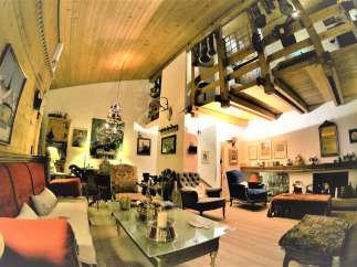 Step into a cozy living space with a unique wooden ceiling and a charming mezzanine.