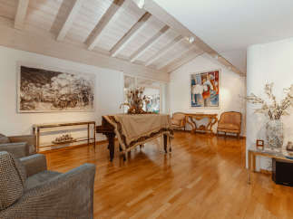Elegant living space featuring a grand piano and hardwood floors.
