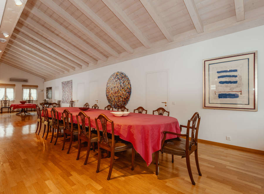 Elegant dining room featuring a long table with a vibrant red tablecloth, perfect for hosting gatherings.