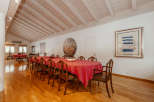 Elegant dining room featuring a long table with a vibrant red tablecloth, perfect for hosting gatherings.