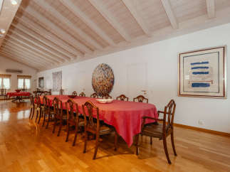 Elegant dining room featuring a long table with a vibrant red tablecloth, perfect for hosting gatherings.