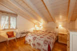 This charming bedroom features a cozy ambiance with its wooden ceiling and walls.