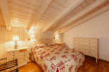 This cozy bedroom features a charming wooden ceiling and walls, creating a warm and inviting atmosphere.