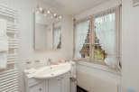 This charming bathroom features a bright and airy design, perfect for a relaxing retreat.