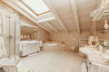 This luxurious bathroom boasts a bright and airy atmosphere with its vaulted ceiling and skylight.