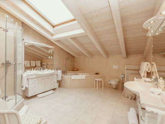 This luxurious bathroom boasts a bright and airy atmosphere with its vaulted ceiling and skylight.