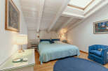 This charming bedroom features a cozy atmosphere with a light blue bedspread and a matching round rug.