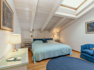This charming bedroom features a cozy atmosphere with a light blue bedspread and a matching round rug.
