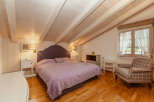 This charming bedroom features a cozy ambiance with its wooden ceiling and warm lighting.