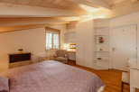 This charming bedroom features a cozy atmosphere with a wooden ceiling and beams.
