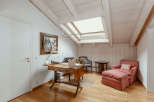 This charming room features a unique sloped ceiling with exposed wooden beams, creating a cozy and inviting atmosphere.