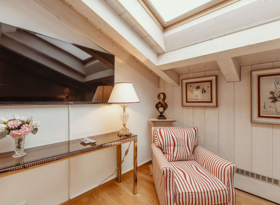 This cozy living space features a stylish armchair with red and white stripes, perfect for relaxing.