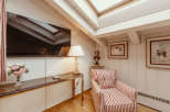 This cozy living space features a stylish armchair with red and white stripes, perfect for relaxing.