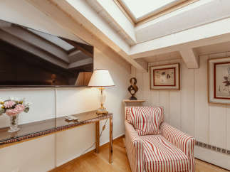 This cozy living space features a stylish armchair with red and white stripes, perfect for relaxing.
