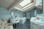 This luxurious bathroom features a unique design with a skylight and exposed wooden beams, creating a bright and airy atmosphere.
