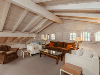 This stunning living room boasts a unique architectural design with a vaulted, wooden ceiling and exposed beams, creating a warm and inviting atmosphere.