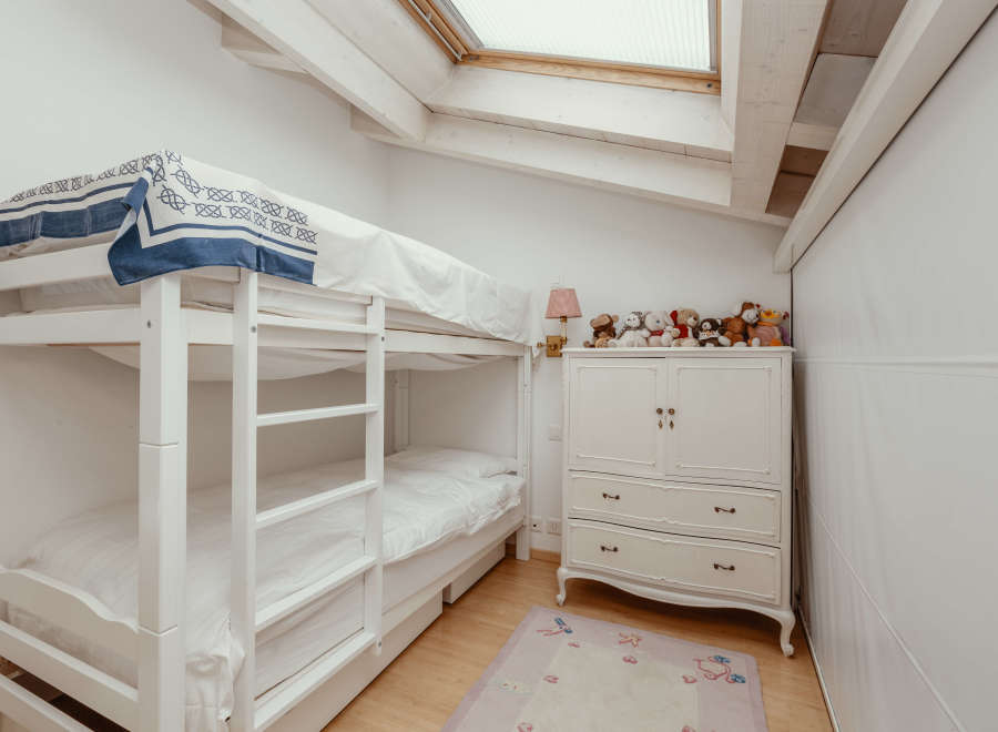 This charming bedroom features a cozy bunk bed, perfect for kids or guests.
