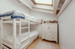 This charming bedroom features a cozy bunk bed, perfect for kids or guests.