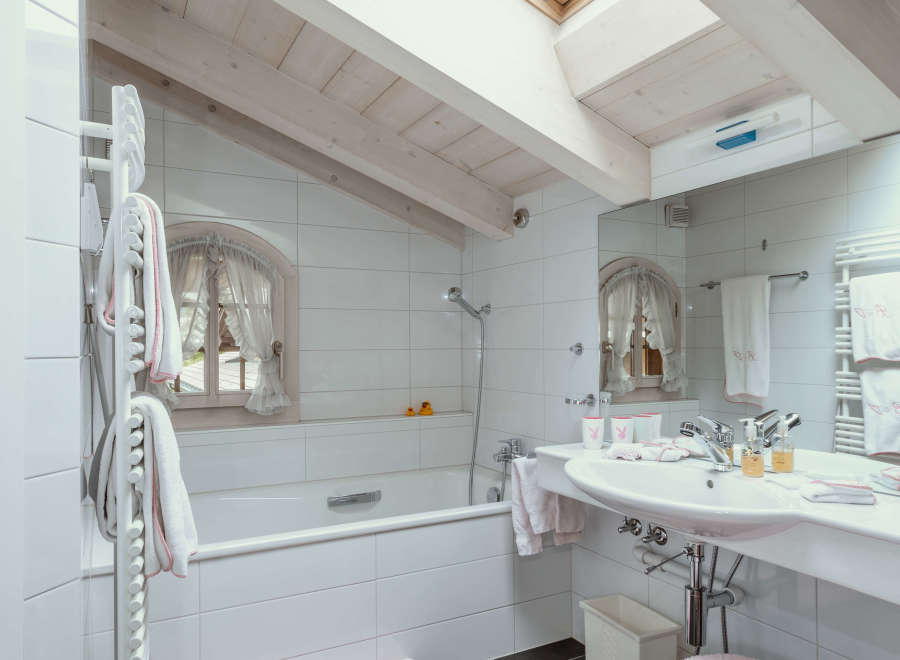 This charming bathroom features a bright and airy design with a skylight that floods the space with natural light.