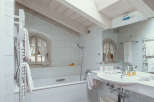 This charming bathroom features a bright and airy design with a skylight that floods the space with natural light.