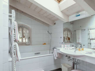 This charming bathroom features a bright and airy design with a skylight that floods the space with natural light.