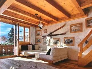 Experience the charm of this cozy chalet, featuring a warm wooden interior and stunning mountain views.