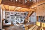 Experience the charm of this rustic chalet, featuring a cozy living area with a loft and wooden beams.