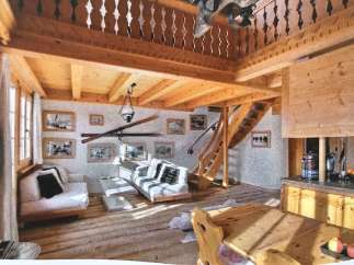Experience the charm of this rustic chalet, featuring a cozy living area with a loft and wooden beams.