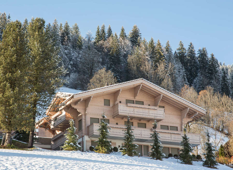 Discover the charm of this stunning wooden chalet nestled in a snowy mountain landscape.