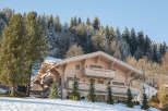 Discover the charm of this stunning wooden chalet nestled in a snowy mountain landscape.