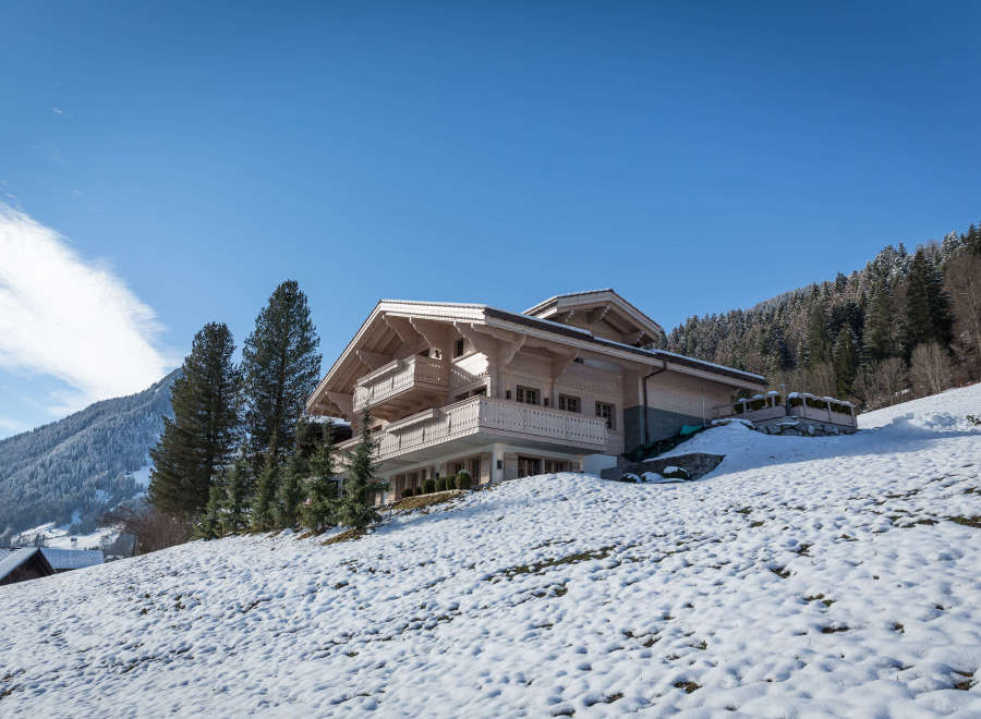 This stunning wooden chalet is nestled in a picturesque snowy landscape.