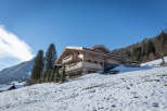 This stunning wooden chalet is nestled in a picturesque snowy landscape.