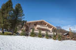 Discover a stunning wooden chalet nestled in a picturesque winter landscape.