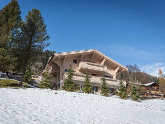 Discover a stunning wooden chalet nestled in a picturesque winter landscape.