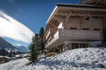 Experience the charm of a traditional wooden chalet nestled in a snowy landscape.