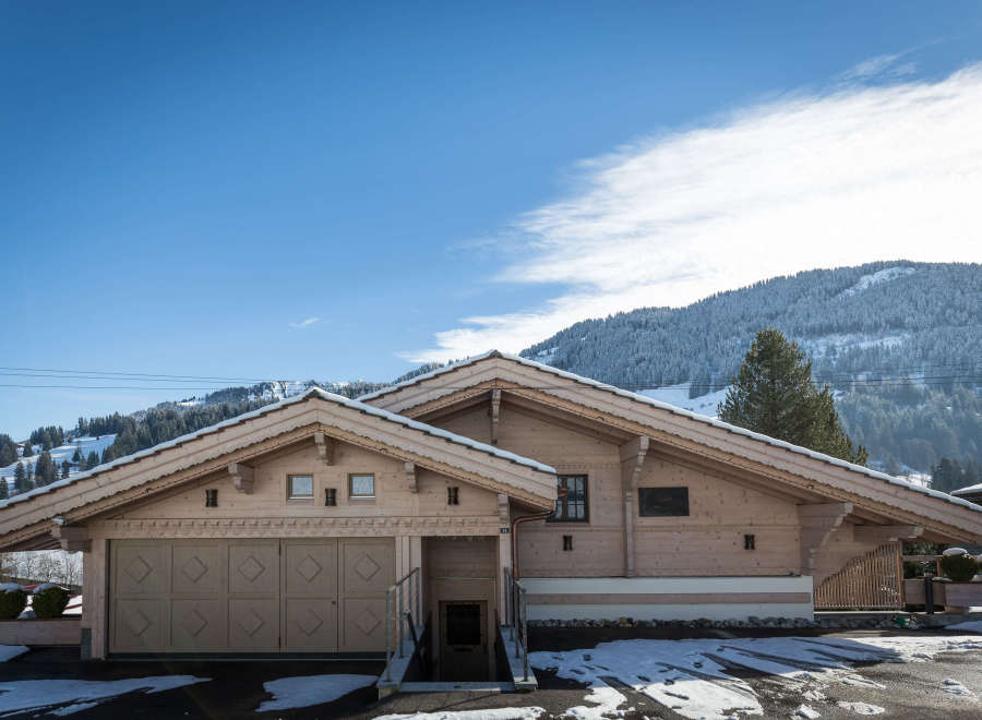 Discover a stunning wooden chalet nestled in a picturesque mountain setting.