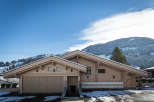 Discover a stunning wooden chalet nestled in a picturesque mountain setting.