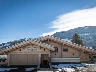 Discover a stunning wooden chalet nestled in a picturesque mountain setting.