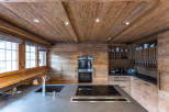 Experience rustic elegance in this stunning kitchen, featuring warm wood paneling and a sleek, modern countertop.
