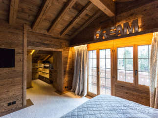 Experience the warmth of this rustic bedroom, featuring stunning wooden accents throughout.