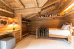 Experience the warmth of this cozy wooden bedroom, perfect for a relaxing retreat.