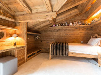 Experience the warmth of this cozy wooden bedroom, perfect for a relaxing retreat.