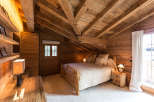 Experience rustic charm in this cozy bedroom, featuring a stunning wooden ceiling and walls.