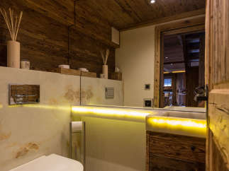This luxurious bathroom features a stunning wooden ceiling and walls, creating a warm and inviting atmosphere.