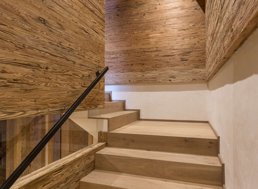 This stunning interior showcases a beautifully crafted wooden staircase, complemented by matching wooden walls and ceiling.